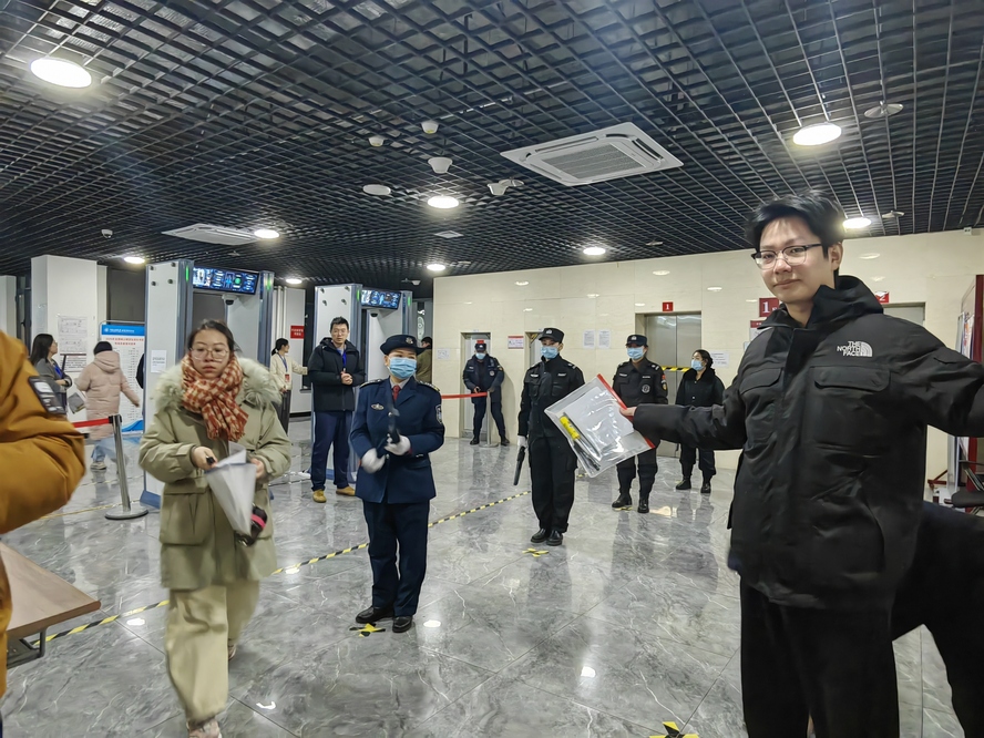 安保人員手持金屬探測器對考生進(jìn)行安檢